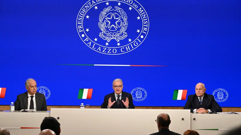 Il sottosegretario alla Presidenza del Consiglio, Alfredo Mantovano (C) con il ministro dell'Interno, Matteo Piantedosi ed il ministro della Giustizia, Carlo Nordio, nel corso della conferenza stampa al termine del Consiglio dei Ministri convocato per la decisione dei giudici sui migranti in Albania, Roma 21 ottobre 2024. ANSA/MAURIZIO BRAMBATTI