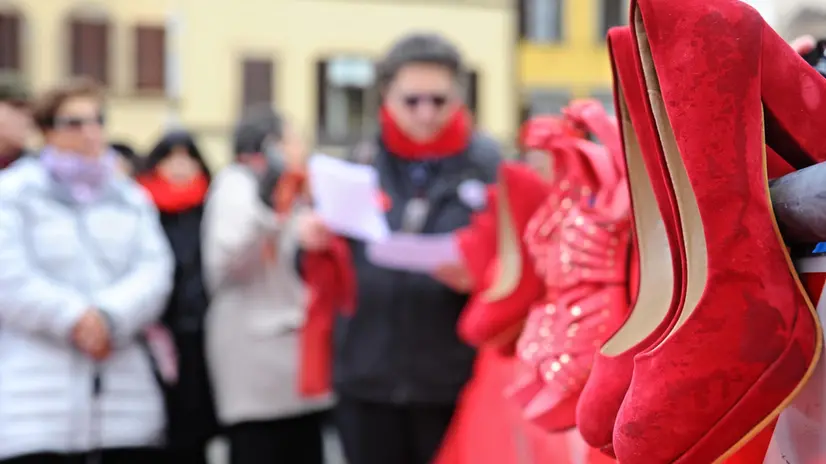 Scarpe rosse durante il flash mob contro la violenza sulle donne in piazza Santa Croce a Firenze, 25 novembre 2013. ANSA/MAURIZIO DEGL' INNOCENTI