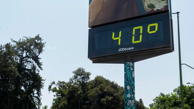 epa12189121 A cyclist rides next to a thermometer showing 40 degrees Celsius in Seville, southern Spain, 21 June 2025, but the temperature is expected to rise above that on this first day of the summer season. EPA/DAVID ARJONA