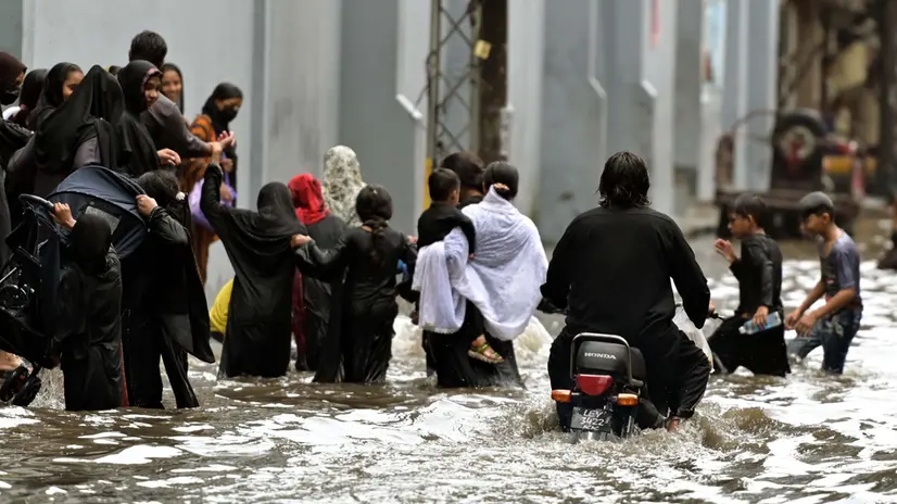 epa12282407 People wade through through heavy monsoon rains in Lahore, Pakistan, 03 August 2025. The Pakistan Meteorological Department warns that the currently weak monsoon currents are set to intensify 04 to 07 of August, bringing further rain and storms to Lahore and central Punjab. EPA/RAHAT DAR 92299