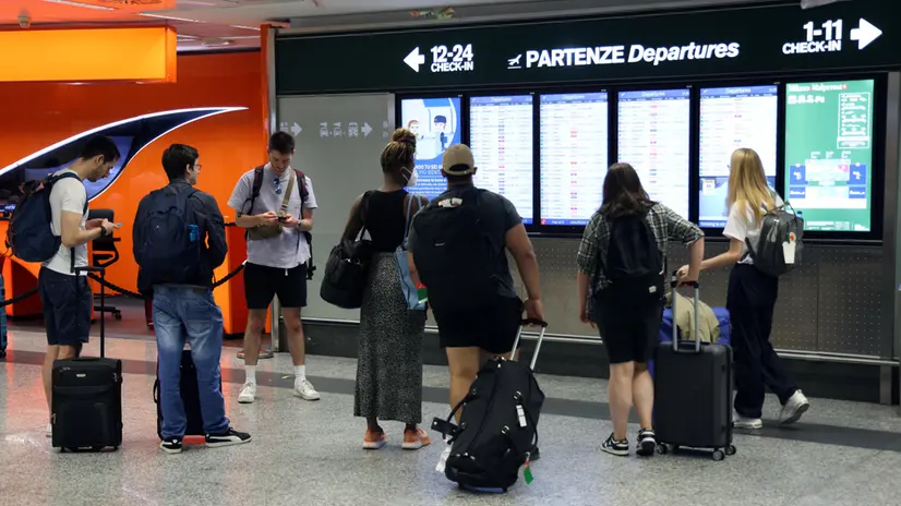 Alcuni passeggeri controllano i monitor che indicano i voli in partenza all’aeroporto di Milano Malpensa. Diversi voli sono in ritardo o sono stati cancellati a causa di uno sciopero di 24 ore nel settore del trasporto aereo. Milano 8 Settembre 2023. ANSA / MATTEO BAZZI