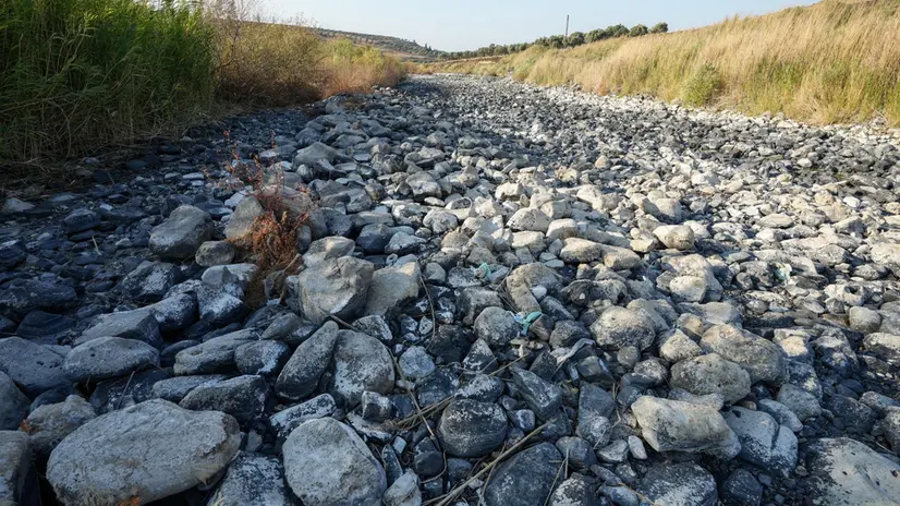 epa12287266 A general view down the dried-out riverbed of the Orontes River in the Jisr al-Shughur, Syria, 06 August 2025. Syria's largest river is drying out due to climate change and excessive water use. According to experts and specialists, this unprecedented drought of the river is due to global climate change first and excessive water use second. EPA/AHMED FALLAHA