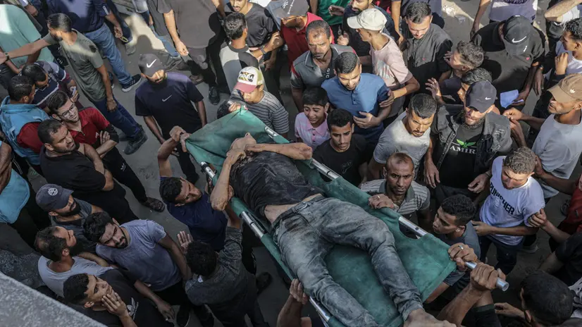 epa12274500 Internally displaced Palestinians carry the body of a young man outside Al Shifa Hospital after he was shot dead at a food distribution point near Zikim in Gaza City, 31 July 2025. More than 80 Palestinians were killed on 30 July after Israeli troops opened fire at a food distribution point near Zikim, the Palestinian Ministry of Health said. EPA/MOHAMMED SABER
