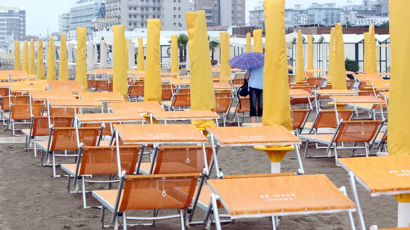La spiaggia di Riccione deserta per la pioggia oggi 14 agosto 2010.Pioggia e cielo coperto in tante regioni d'Italia, con molte spiagge vuote e gli ombrelloni chiusi. Si presenta così la vigilia di ferragosto, con il maltempo diffuso su tutte le regioni con piogge e temporali anche di forte intensità inizialmente sul nordovest ed in graduale estensione dalla tarda mattinata alle restanti regioni. GIORGIO BENVENUTI