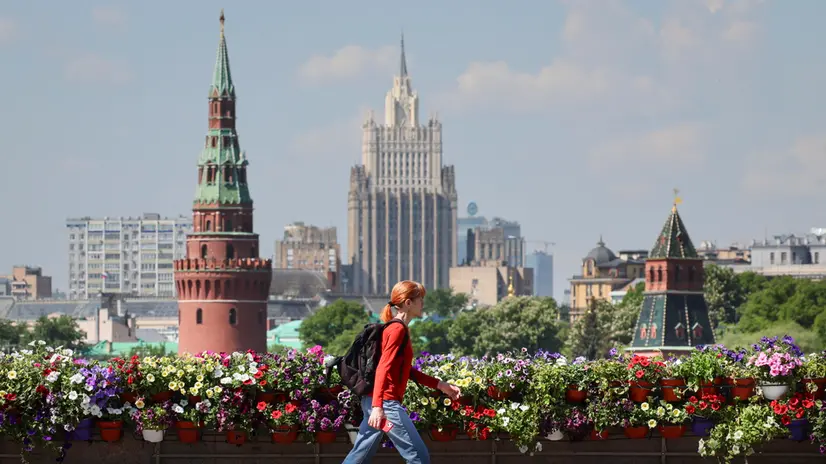 epa12128144 A woman walks on the Bolshoy Moskvoretsky Bridge, decorated with flowers, in front of the Kremlin tower (L) and the main building of the Ministry of Foreign Affairs (C) during the festival of urban landscape design 'Summer in Moscow. Gardens and Flowers' in Moscow, Russia, 23 May 2025. More than 50 traditional exhibition gardens and landscape spaces with walking and lounge areas will gradually appear across the capital. Over 650 small floral installations will transform familiar urban spaces. The festival of urban landscape design, 'Summer in Moscow. Gardens and Flowers,' will run until 8 September 2025. EPA/YURI KOCHETKOV