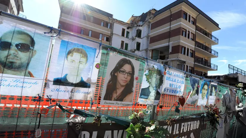 L'area dove sorgeva la Casa dello studente all'Aquila, con le foto degli otto ragazzi che morirono nel crollo del palazzo, 17 marzo 2012. ANSA / ETTORE FERRARI