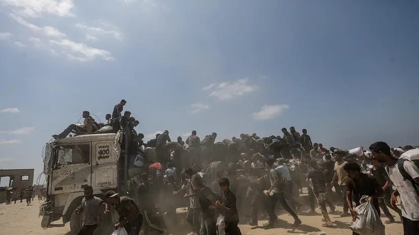 epa12290441 Internally displaced Palestinians try to grab bags of flour from an aid truck near a food distribution point in Zikim, northern Gaza Strip, 08 August 2025. Humanitarian organizations have warned of an imminent food catastrophe for thousands of children, a crisis caused by severe food insecurity, a decline in health services, and ongoing restrictions on humanitarian aid and essential supplies. EPA/MOHAMMED SABER