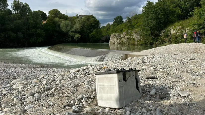 Il greto del fiume Natisone con un oggetto che indica il punto in cui tre ragazzi si sono abbracciati prima di essere travolti dalla piena