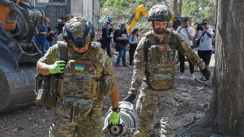 epa12277762 Experts carry a part of the rocket at the site of a rocket strike on a nine-storey residential building in Kyiv, Ukraine, 01 August 2025. The Ukrainian capital on 01 August observed a day of mourning after a Russian attack claimed 31 lives and injured over 150 people on 31 July, according to the State Emergency Service. EPA/SERGEY DOLZHENKO