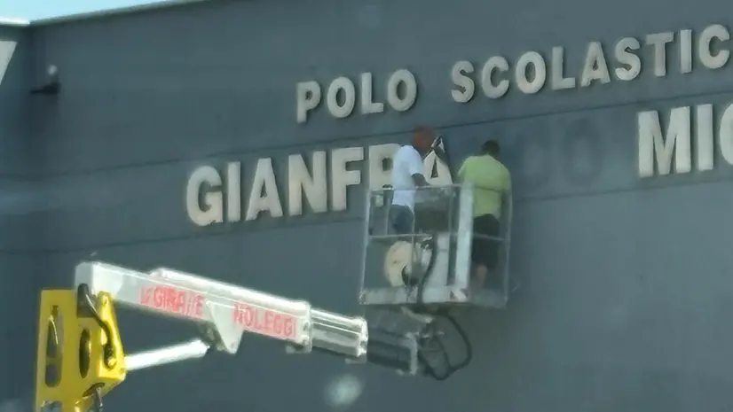 Gli operai rimuovono la scritta dalla scuola di Adro © www.giornaledibrescia.it