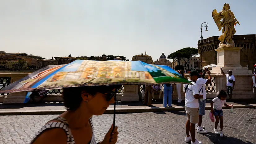 People holds umbrella to shelter from sunlight on Sant'Angelo Bridge on a hot day in Rome, Italy, 10 August 2025. ANSA/FABIO FRUSTACI