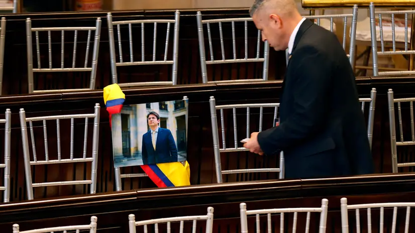 epa12250362 A person looks at a photograph of Senator Miguel Uribe placed on a chair during the opening of the new session of Congress in Bogota, Colombia 20 July 2025. Colombian President Gustavo Petro highlighted the economic progress he has made in his first three years in office but acknowledged that he has not been able to push forward the policy of “total peace” with armed groups, one of his major campaign promises. EPA/MAURICIO DUENAS CASTANEDA