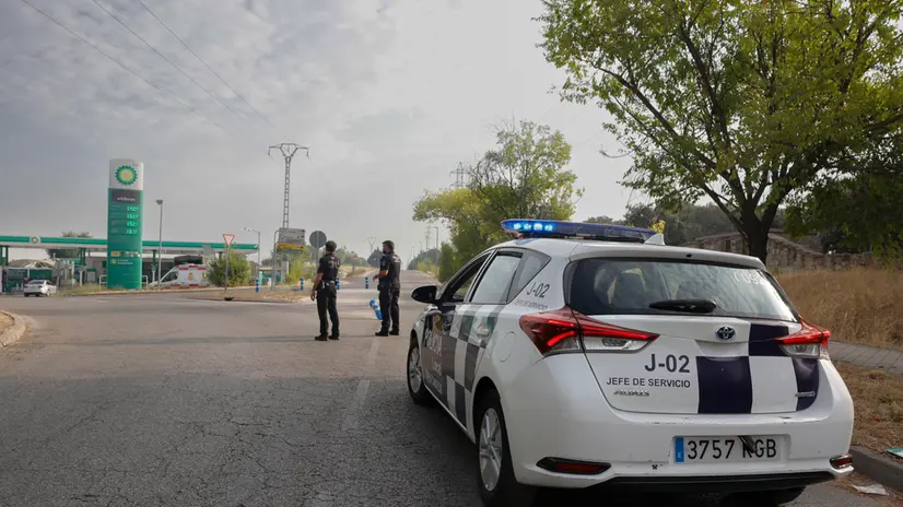 epa12294774 Local police stand by at a gas station in Tres Cantos, Madrid, Spain, 12 August 2025. A forest fire was declared late on 11 August in Tres Cantos, forcing the evacuation of three housing estates in the area. A 50-year-old man injured in the fire died on 12 August as a result of his injuries, while an 83-year-old man remains in hospital EPA/ZIPI