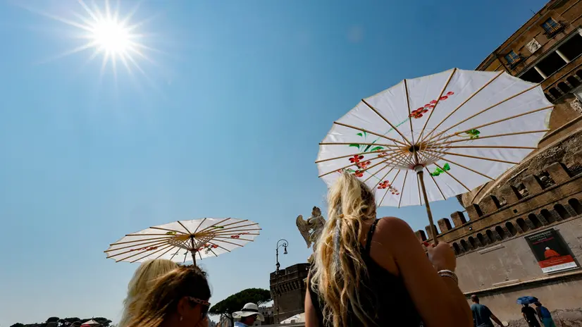 People holds umbrella to shelter from sunlight on Sant'Angelo Bridge on a hot day in Rome, Italy, 10 August 2025. ANSA/FABIO FRUSTACI