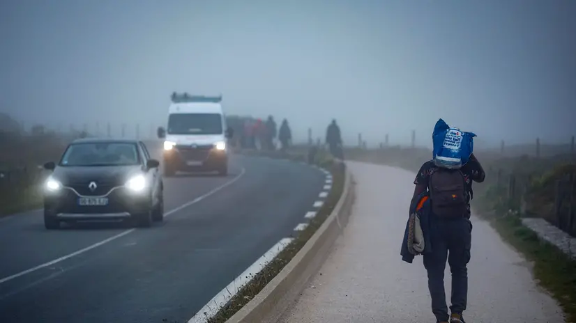 epaselect epa12244846 Migrants walk along the road early morning after attempting to cross the English Channel outside Wimereux, north of France, 18 July 2025. On July 10, 2025, during President Macron's state visit to the UK, an agreement was reached on cross-Channel migration. France agreed to accept back individuals who crossed the Channel but are not eligible for asylum in the UK. In exchange, the British government promised to accept individuals who can be legally integrated. Since the beginning of 2025, an estimated 21,000 people have reached the British coasts in small boats. EPA/YOAN VALAT