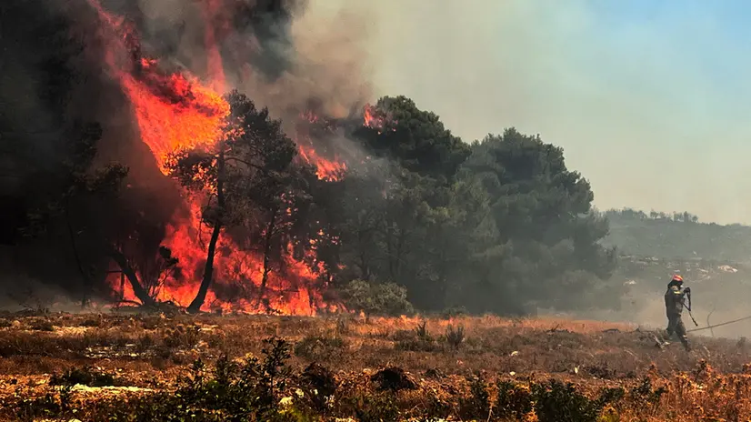 epaselect epa12295013 A firefighter battles a wildfire that erupted in a forest near the village of Agalas on Zakynthos Island, Ionian Sea, Greece, 12 August 2025. According to a briefing from the Fire Brigade, due to a change in the direction of strong winds blowing on the island of Zakynthos, the flames have reached the yards of houses on the outskirts of the village of Agalas, where strong firefighting forces are trying to contain the flames. EPA/COSTAS SYNETOS