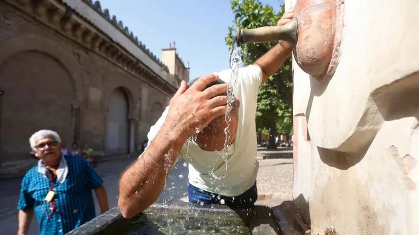 epa12295473 A person splashes water on their head to combat the heat in Cordoba, Spain, 12 August 2025. The Spanish State Meteorological Agency (AEMET) issued a red warning for high temperatures in Andalusia, specifically in the Cordoba and Seville countryside, where temperatures could reach 44 degrees Celsius. EPA/SALAS
