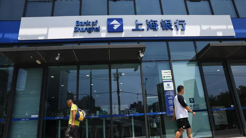 epa12250477 People walk past a bank in the Central Business District (CBD) area in Beijing, China, 21 July 2025. China's one-year loan prime rate was held steady at 3.0 percent, while the five-year benchmark loan rate remained unchanged at 3.5 percent, the People's Bank of China (PBOC) said. EPA/WU HAO