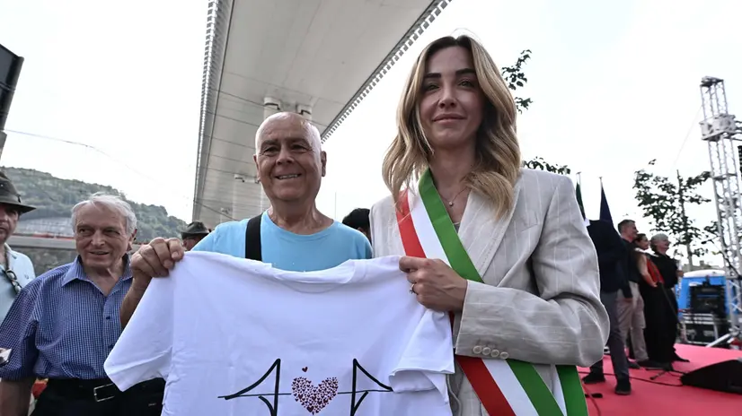 La sindaca di Genova Silvia Salis con la maglietta per la raccolta fondi per le vittime del crollo, durante la commemorazione delle 43 vittime del crollo del ponte Morandi. Genova, 14 agosto 2025. ANSA/LUCA ZENNARO