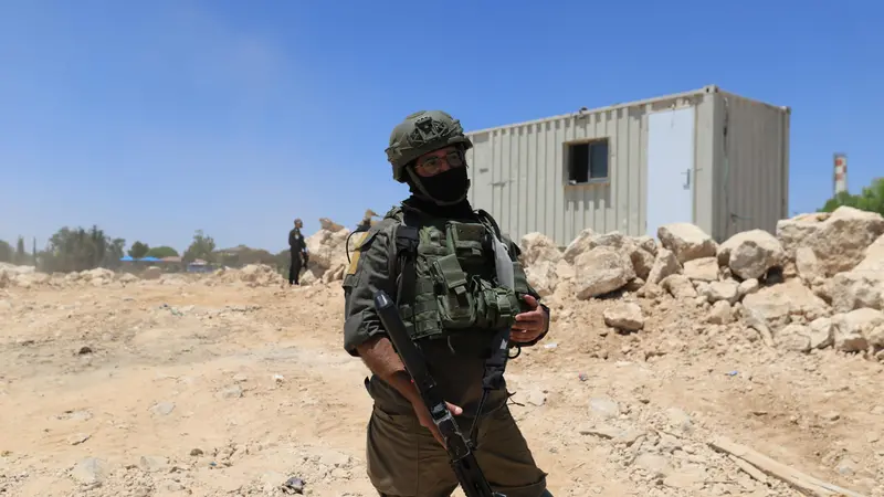 epa12275316 An Israeli soldier stands guard in Khirbet Umm Al-Khair, Hebron governorate, West Bank, 31 July 2025. According to the Palestinian Ministry of Health, Palestinian teacher and human rights activist Odeh Al-Hathalin, 31, succumbed to his wounds after being shot on 28 July by an Israeli settler while reportedly trying to prevent the bulldozing of Palestinian lands in the village. EPA/ALAA BADARNEH