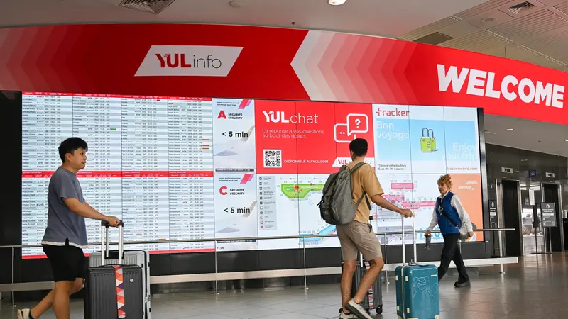 epa12300323 Travellers walk by a flight information board at Montreal-Trudeau International Airport, in Montreal, Quebec, Canada, 14 August 2025. Air Canada is facing a near-total shutdown, as the union plans to strike after talks with flight attendants broke down over pay and unpaid work. EPA/GRAHAM HUGHES
