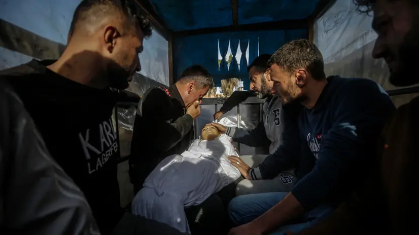 epa11790395 GRAPHIC CONTENT - Palestinians react as a father (rear) carries the body of his son during his funeral at Al Aqsa Martyrs hospital in Deir Al Balah, central Gaza Strip, 22 December 2024. According to the Palestinian Ministry of Health in Gaza, at least five Palestinians were killed following an Israeli airstrike in Al Bureij refugee camp, central Gaza. More than 45,000 Palestinians and over 1,400 Israelis have been killed, according to the Palestinian Health Ministry and the Israeli Army, since Hamas militants launched an attack against Israel from the Gaza Strip on 07 October 2023, and the Israeli operations in Gaza and the West Bank which followed it. EPA/MOHAMMED SABER -- ATTENTION EDITORS: GRAPHIC CONTENT