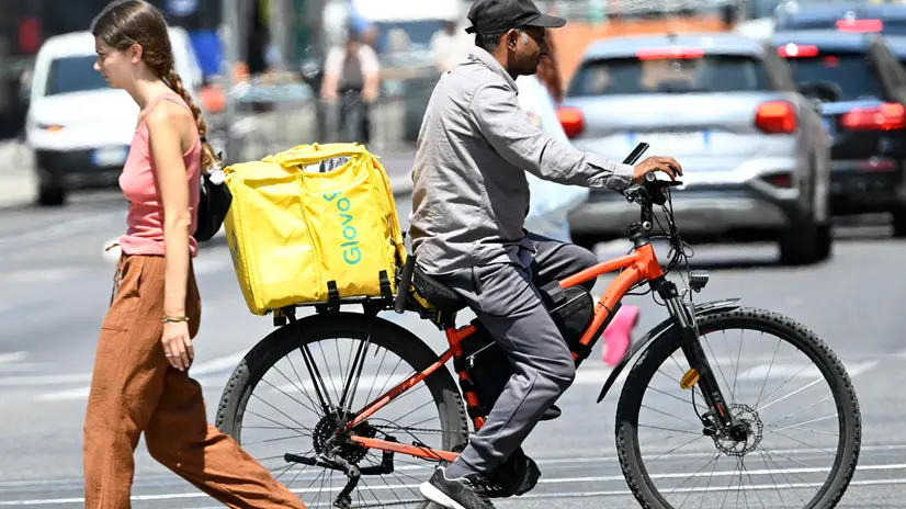 Un rider al lavoro in una via del cento, Milano, 2 luglio 2025. ANSA/DANIEL DAL ZENNARO