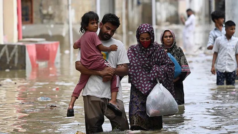 epa12311878 People wade through rainwater after torrential rains in Karachi, Pakistan, 20 August 2025. Since the start of the monsoon season on 26 June, the death toll from rains and flooding in Pakistan has reached at least 748. The National Disaster Management Authority (NDMA) reported that an additional 978 people have been injured. EPA/SHAHZAIB AKBER