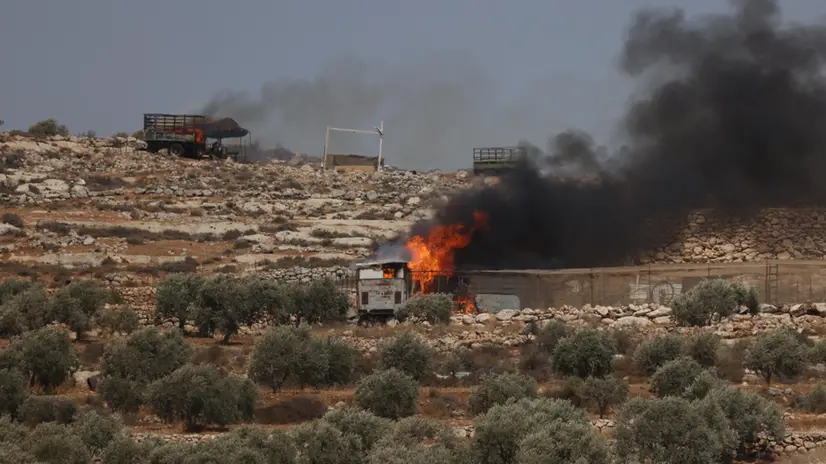 epa12304532 Smoke rises from burning vehicles as Israeli settlers attack the village of Der Abu Falah, east of Ramallah, 16 August 2025. According to the Palestinian Health Ministry, at least four Palestinians were wounded in the incident. EPA/ALAA BADARNEH