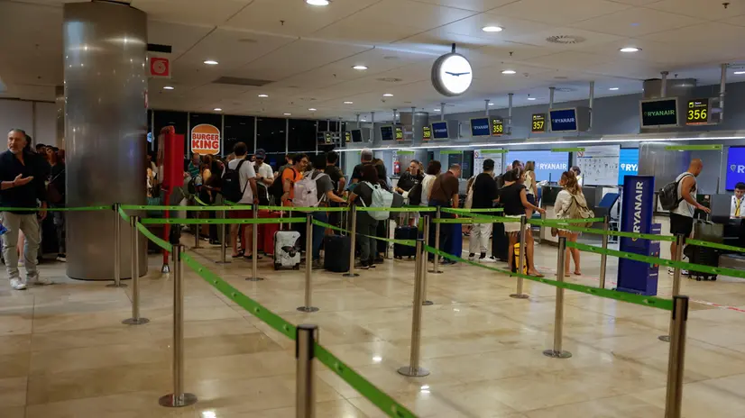 epa12301865 Passengers wait at Ryanair's check-in desks at Adolfo Suarez Madrid Barajas in Madrid, Spain, 15 August 2025. Unions within the Ryanair ground-handling staff are on strike in Spain that is expected to affect several Spanish airports and could lead to delays and cancellations. EPA/J.P. Gandul