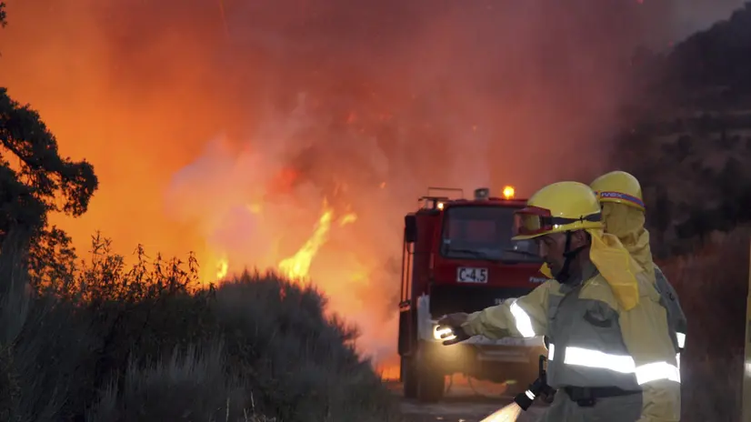 epa05472118 Firemen prepare to fight in a fire which advances out of control between the villages of Serradilla del Llano and La Atalaya in Salamanca, western Spain, 10 August 2016. EPA/CARLOS GARCIA