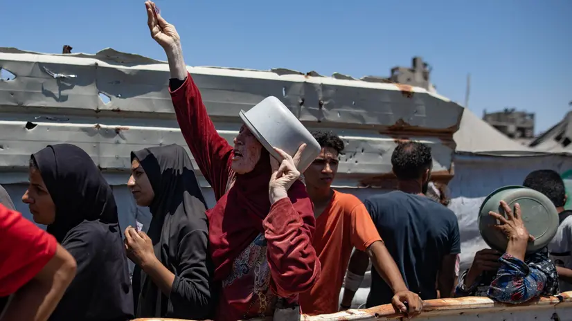 epa12247603 Internally displaced Palestinians gather outside a charity kitchen to receive limited food rations amid the lack of food availability, in Gaza City, 19 July 2025. EPA/HAITHAM IMAD