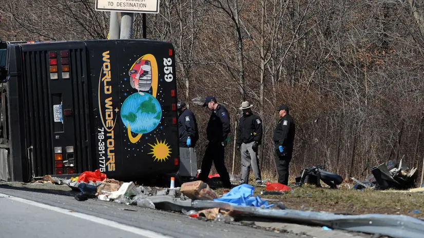 epa02629593 Emergency personnel work at the scene of the deadly bus crash in the Bronx, New York, New York, USA, 12 March 2011. Officials said at least 14 people died and another 20 were hospitalized in an early morning crash on a tour bus returning from Mohegan Sun Casino to the Chinatown section of New York. EPA/ANDREW GOMBERT