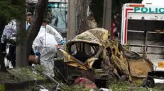 epa12315745 Members of the Criminal Investigation and Interpol Directorate (DIJIN) inspect a damaged vehicle near the Marco Fidel Suarez Military Aviation School in Cali, Colombia, 21 August 2025, after an attack. EPA/Ernesto Guzman