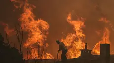 epa12312897 A local resident tries to fight with a forest fire in Lourical do Campo, Castelo Branco, Portugal, 20 August 2025. According to preliminary official data, as of August 19, 2025, over 201,000 hectares had burned in Portugal, surpassing the total burned in all of 2024. EPA/PAULO NOVAIS