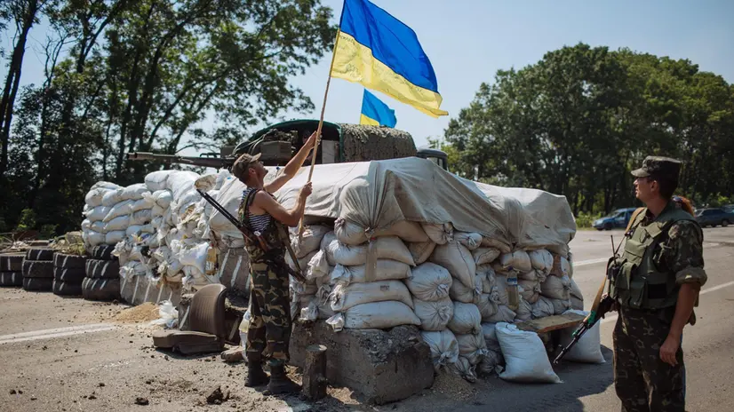 epa04337908 Ukrainian soldier sets up Ukrainian national flag at a checkpoint near Eastern Ukrainian village Nikishino, some 20 kms from village Grabovo, close to the village where the Malaysia Airlines flight MH17 crashed, in Ukraine, 01 August 2014. A group of international experts managed to reach the Malaysia Airlines plane believed to have been shot down on 17 July by pro-Russian separatists in Ukraine, just as the European Union turned up the heat on Moscow with unprecedented economic sanctions. EPA/ROMAN PILIPEY