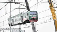 Una squadra di operai al lavoro per rimuovere i vagoni del treno deragliato - Foto Ansa © www.giornaledibrescia.it