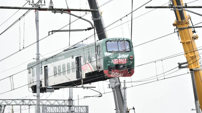 Una squadra di operai al lavoro per rimuovere i vagoni del treno deragliato - Foto Ansa © www.giornaledibrescia.it