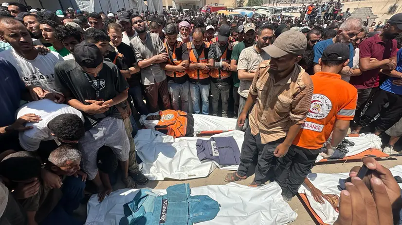 epaselect epa12321404 People pray in front of the bodies of Palestinians killed in an Israeli airstrike at Nasser Hospital in Khan Younis, southern Gaza Strip, 25 August 2025. According to the Palestinian Health Ministry, the airstrike hit the fourth floor of the Nasser Medical Complex, followed by a second attack upon the arrival of ambulance crews to retrieve the injured and the dead, leaving at least 20 killed, including 5 journalists. EPA/HAITHAM IMAD