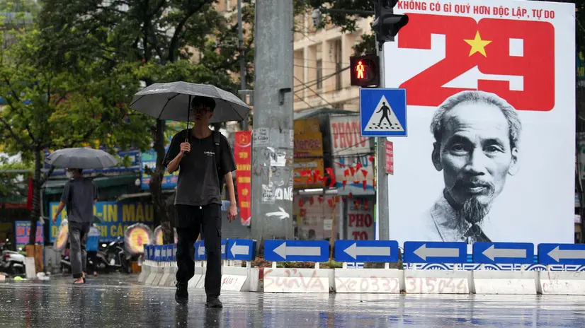 epa12321219 A person holding an umbrella walks under the rain in Hanoi, Vietnam, 25 August 2025. Typhoon Kajiki made landfall on 25 August, bringing torrential rains to Vietnam's north-central coast, prompting mass evacuations and the closure of airports and schools. EPA/LUONG THAI LINH