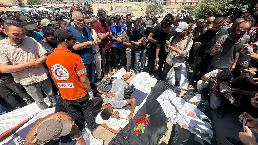epa12321408 People pray in front of the bodies of Palestinians killed in an Israeli airstrike at Nasser Hospital in Khan Younis, southern Gaza Strip, 25 August 2025. According to the Palestinian Health Ministry, the airstrike hit the fourth floor of the Nasser Medical Complex, followed by a second attack upon the arrival of ambulance crews to retrieve the injured and the dead, leaving at least 20 killed, including 5 journalists. EPA/HAITHAM IMAD