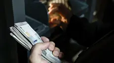 epa11787388 A women withdraws money after banks reopen in Damascus, Syria, 19 December 2024. Syrian rebels entered Damascus on 08 December 2024 and announced in a televised statement the 'Liberation of the city of Damascus and the overthrow of Bashar al-Assad', as well as the release of all the prisoners. EPA/ANTONIO PEDRO SANTOS