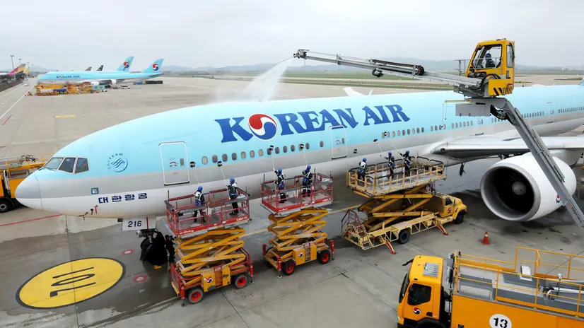 epa11299109 Workers scrub the fuselage of a Korean Air plane with mops at a hangar in Incheon International Airport, in Incheon, South Korea, 25 April 2024. EPA/YONHAP / POOL SOUTH KOREA OUT