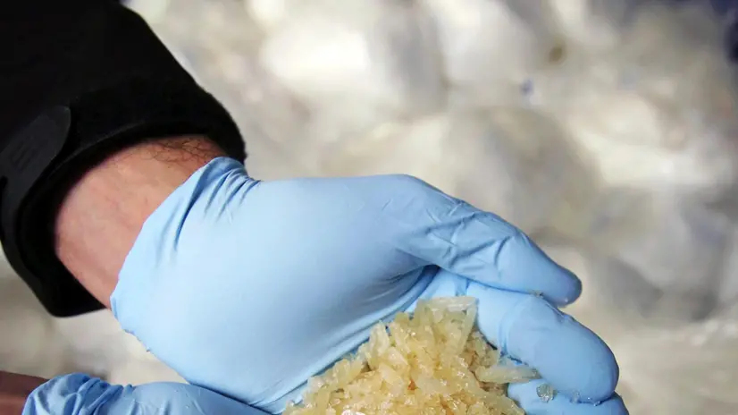 An investigator of the Federal Criminal Police Office (BKA) holds some of 2.9 tons of seized Crystal Meth on display for media in Wiesbaden, Germany, 13 November 2014. ANSA/FREDRIK VON ERICHSEN