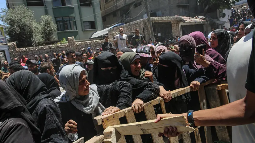 epa12198723 Displaced Palestinians wait to receive aid through the WFP after it successfully arrived at the organization’s warehouses in Gaza City, 26 June 2025. According to the UN half a million people, or one in five people in the Strip are facing starvation while the entire population of the Gaza Strip continues to face a critical risk of famine following 19 months of conflict, mass displacement and severe restrictions on humanitarian aid. EPA/MOHAMMED SABER