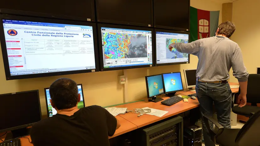 La sala di controllo della Protezione Civile della Regione Liguria, Genova, 04 novembre 2014. Nuova allerta meteo del Dipartimento della Protezione Civile: la perturbazione atlantica che sta interessando l'Italia porterà nelle prossime ore ancora piogge e temporali anche molto intensi su buona parte del paese. Sulla base delle previsioni disponibili, il Dipartimento ha dunque valutato una criticità rossa, il livello più alto, per rischio idrogeologico su Liguria e Toscana. ANSA/LUCA ZENNARO