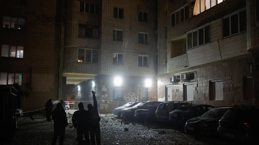 epa11816392 Local people stand near damaged cars at the site of drone debris falling on a residential building, in Kyiv, Ukraine, 10 January 2025, amid the Russian invasion. Debris of a Russian unmanned aerial vehicle (UAV) hit a high-rise building in the Solomianskyi district of Kyiv, the head of the Kyiv City Military Administration, Tymur Tkachenko wrote on telegram, adding that no injuries were reported in the incident. EPA/SERGEY DOLZHENKO