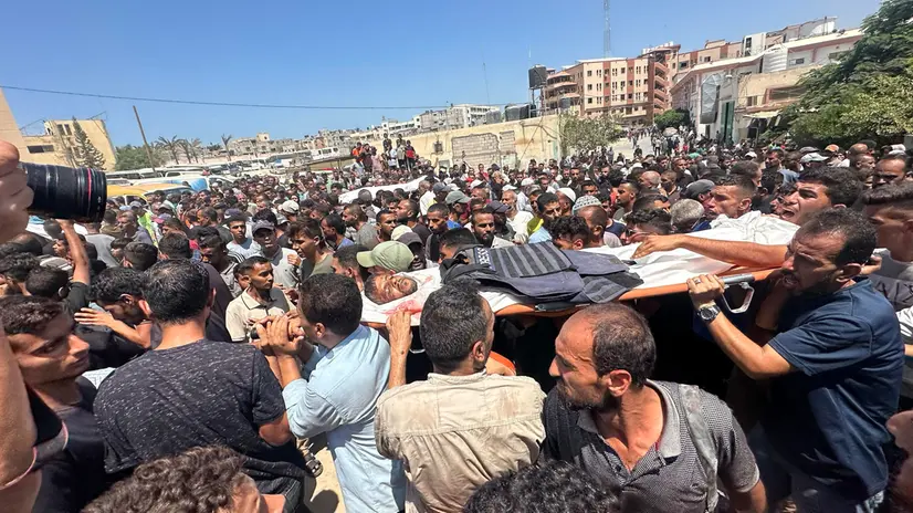 epa12321407 People carry the coffin of Palestinian journalist Hossam Al-Masri, who was killed in an Israeli airstrike on Nasser Hospital in Khan Younis, southern Gaza Strip, 25 August 2025. According to the Palestinian Health Ministry, the airstrike hit the fourth floor of the Nasser Medical Complex, followed by a second attack upon the arrival of ambulance crews to retrieve the injured and the dead, leaving at least 20 killed, including 5 journalists. EPA/HAITHAM IMAD