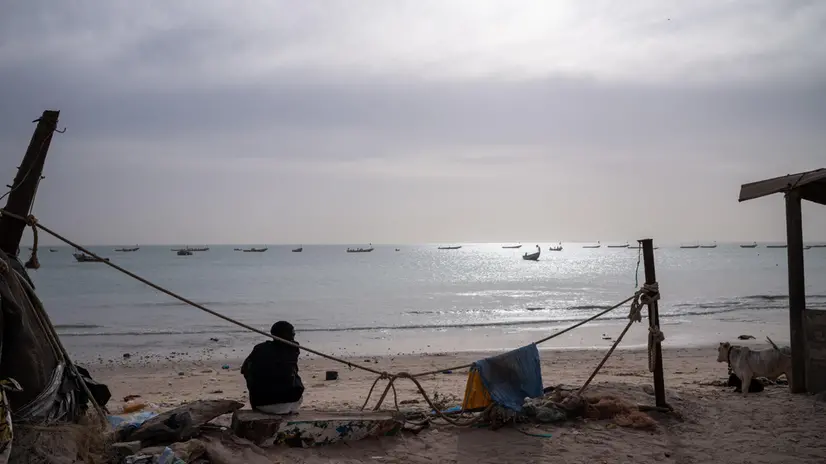 epa11846368 A young man sits on the beach in Bargny, 30 kilometres west of Dakar, Senegal, 17 January 2025 (issued 23 January 2025). In October 2023 from this location, a pirogue with over 100 would-be migrants left Senegal for Spain in search of better opportunities and disappeared forever. 'Nobody (of the more than a hundred who were travelling on the boat) has been recovered,' said local resident Binata Dieng, whose 19-year-old daughter was on board. According to figures from the European Border and Coast Guard Agency (Frontex), more than 87,000 people arrived in Spain via the Atlantic route in 2023 and 2024, coming not only from Senegal but also from countries such as Mauritania and Gambia. In Bargny, the local government estimates that nearly 3,000 people from the settlement have taken this migratory route in the last two years. Bargny symbolises one of the greatest tragedies of emigration and the intersection between environmental deterioration and socio-economic fragility in coastal cities in Senegal. EPA/JEROME FAVRE