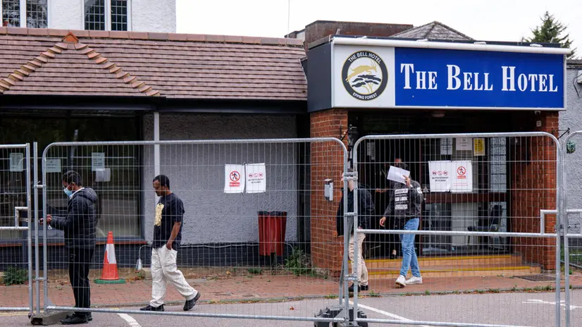 epa12312194 Staff and asylum seekers walk outside The Bell Hotel in Epping, Essex, Britain, 20 August 2025. Asylum seekers sheltering in the hotel have been instructed to vacate the premises by 12 September 2025, as the UK High Court has granted the Epping Forest District Council a temporary injunction blocking migrants from being housed at the facility. EPA/TOLGA AKMEN